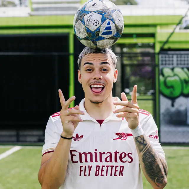 Dudu Footz equilibrando uma bola de futebol na cabeça em um campo