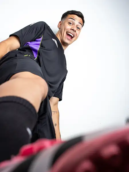 Dudu Footz sorrindo para a câmera em ângulo baixo, em pose descontraída